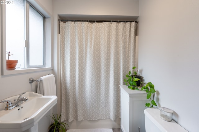 full bathroom with shower / bath combo with shower curtain and a sink