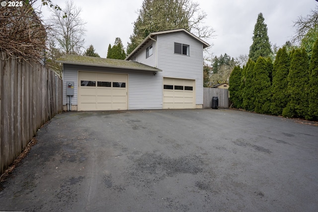 garage with driveway and fence