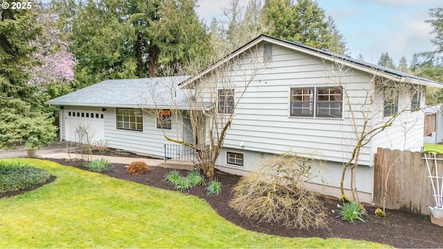 back of house with a yard, fence, and a garage