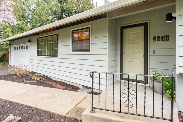 doorway to property featuring a garage and a porch