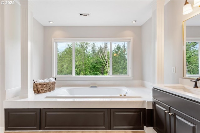 full bathroom featuring a garden tub and vanity