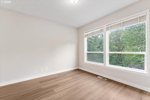 unfurnished room with baseboards and wood finished floors