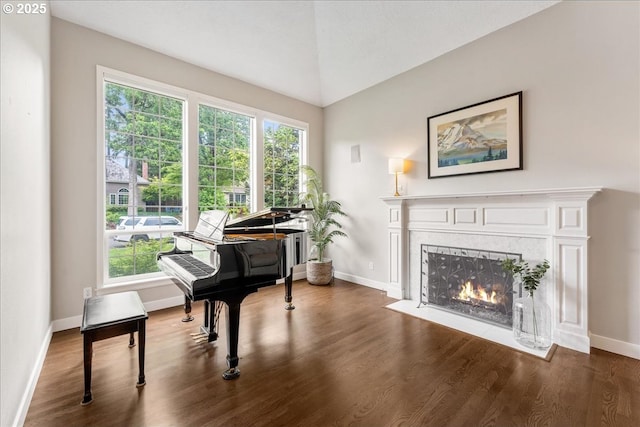 sitting room featuring wood finished floors, a high end fireplace, and baseboards