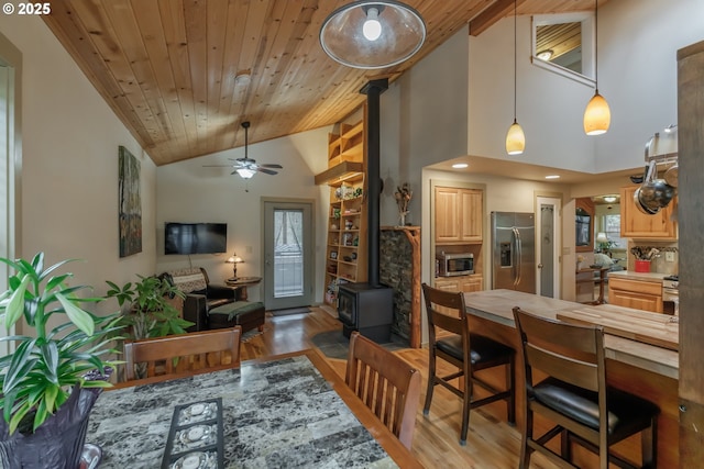 23830 Old Peak Rd, Philomath, OR 97370 - dining space featuring a wood stove, wood finished floors, ceiling fan, wood ceiling, and high vaulted ceiling