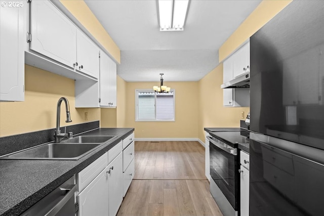 307 NE 85th St Unit B, Vancouver, WA 98665 - kitchen featuring appliances with stainless steel finishes, dark countertops, white cabinets, under cabinet range hood, and light wood-style floors