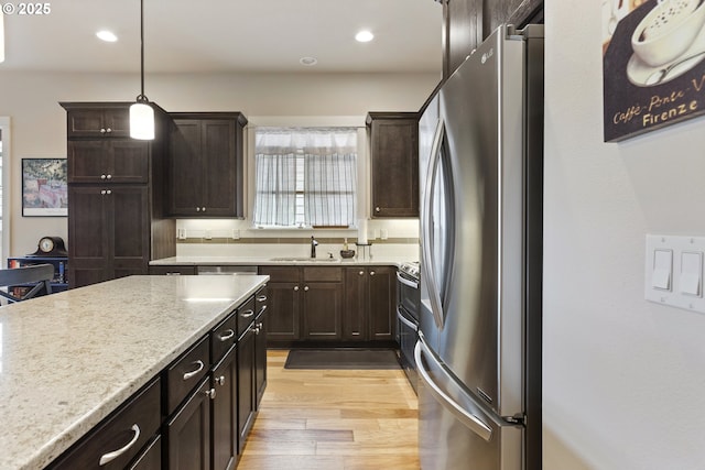 16033 SW 2nd St, Sherwood, OR 97140 - kitchen with freestanding refrigerator, a sink, light wood-style flooring, dark brown cabinetry, and recessed lighting