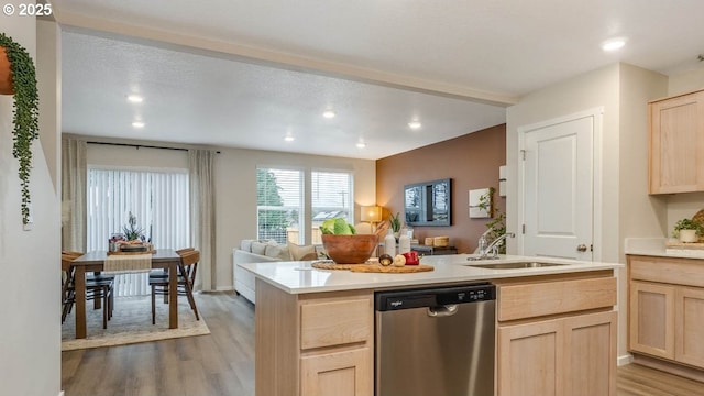 kitchen with light brown cabinetry, sink, a center island, stainless steel dishwasher, and light hardwood / wood-style floors