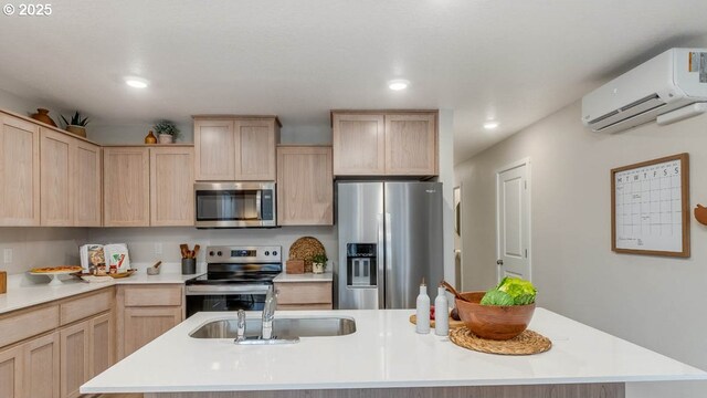 kitchen with a breakfast bar, light brown cabinets, sink, and appliances with stainless steel finishes