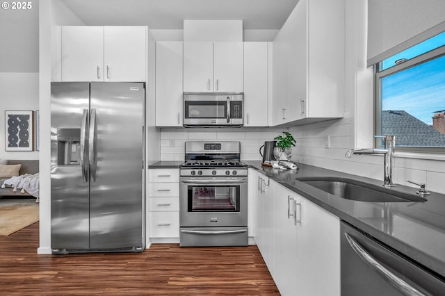 kitchen with sink, dark wood-type flooring, white cabinets, and appliances with stainless steel finishes