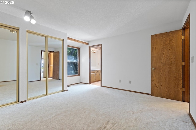 16445 SW Meadowood Way, Portland, OR 97224 - unfurnished bedroom with two closets, carpet floors, ensuite bath, and a textured ceiling