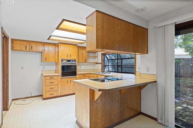 16445 SW Meadowood Way, Portland, OR 97224 - kitchen featuring black appliances, a peninsula, light flooring, and light countertops