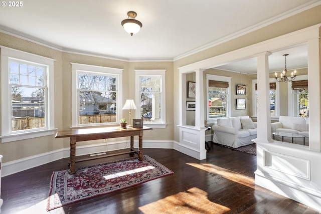 interior space featuring ornate columns, ornamental molding, dark wood-type flooring, and a notable chandelier