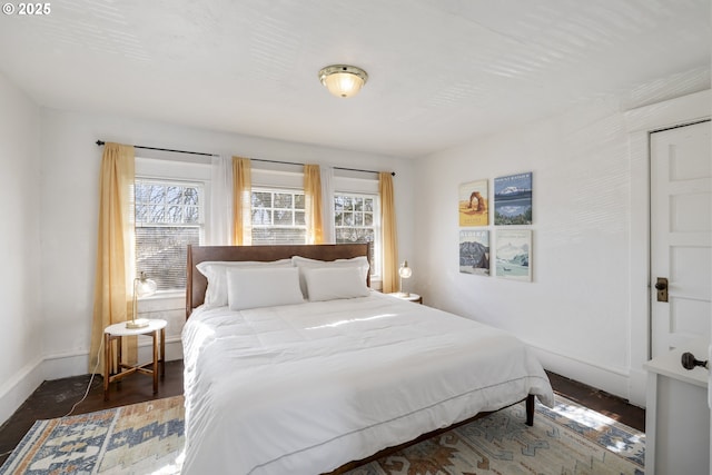 bedroom featuring multiple windows and dark hardwood / wood-style flooring