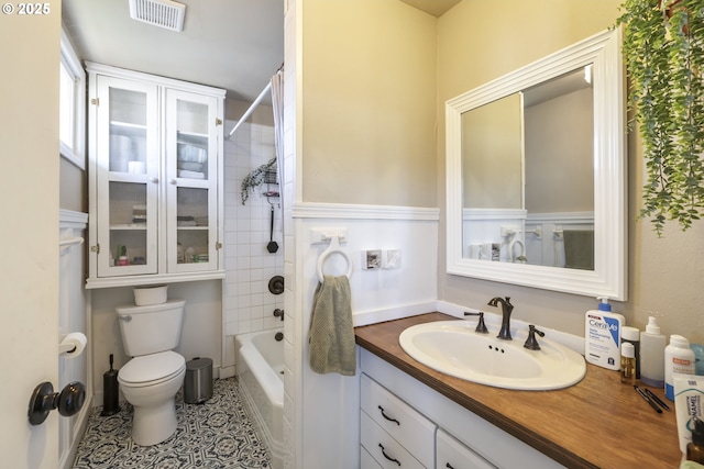 full bathroom featuring tiled shower / bath, vanity, toilet, and tile patterned flooring