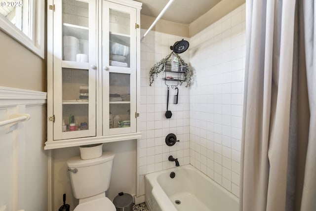 bathroom featuring shower / bath combination with curtain and toilet