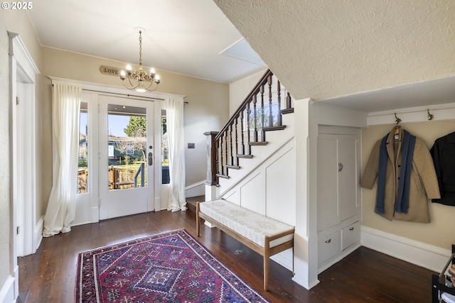 entrance foyer featuring an inviting chandelier, dark hardwood / wood-style floors, and a textured ceiling