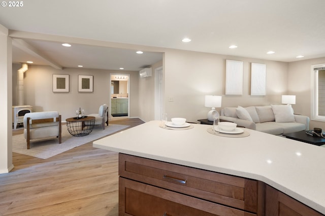 kitchen with light wood-style flooring, open floor plan, recessed lighting, light countertops, and baseboards