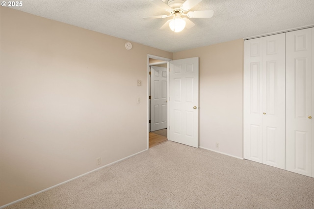 unfurnished bedroom with carpet floors, a textured ceiling, a closet, baseboards, and a ceiling fan
