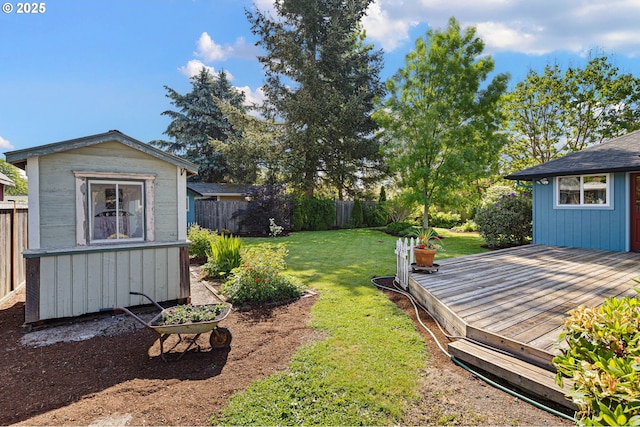 view of yard with a wooden deck, an outdoor structure, and a shed