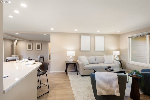 living room with recessed lighting, light wood-style floors, and baseboards