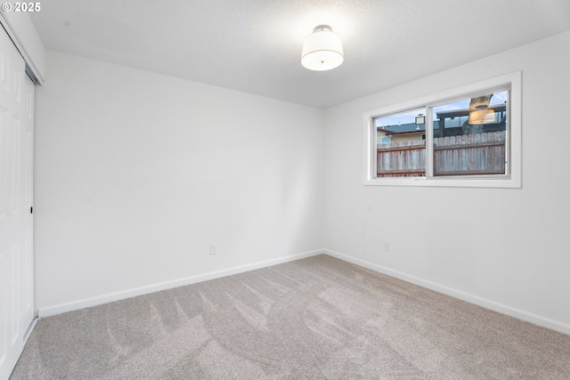 carpeted spare room with a textured ceiling