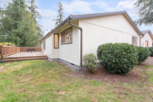 view of home's exterior featuring crawl space, a lawn, a chimney, and a wooden deck