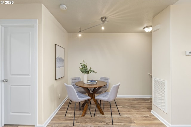 dining room with light wood-style flooring, baseboards, and visible vents