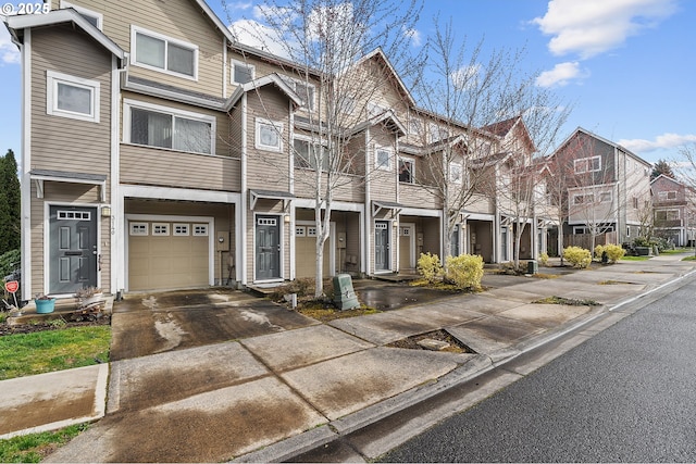 townhome / multi-family property featuring a residential view, an attached garage, and concrete driveway