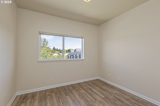 unfurnished room featuring wood finished floors and baseboards