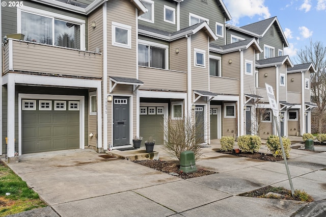 view of property featuring a residential view, a garage, and driveway