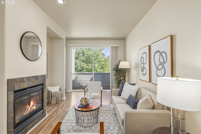 living area with wood finished floors, a fireplace, and baseboards