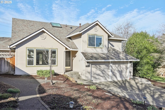 view of front of home featuring an attached garage, a shingled roof, fence, and concrete driveway