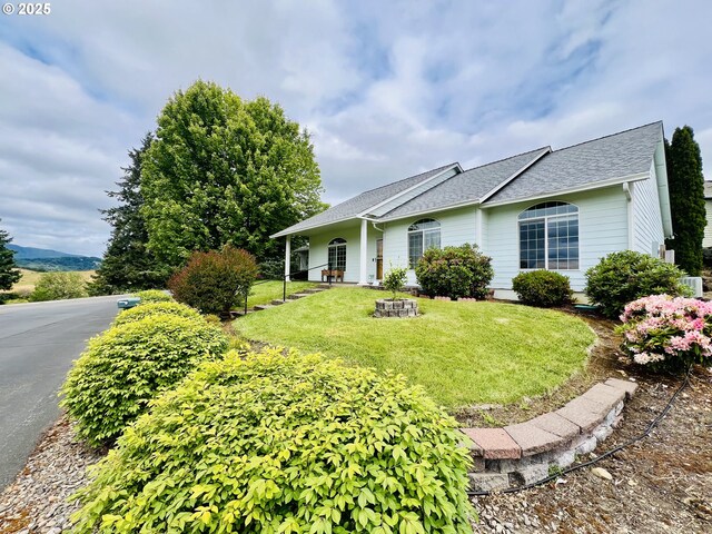 2295 Chi Chi Ln, Sutherlin, OR 97479 - view of front of house featuring a front lawn, roof with shingles, and a fire pit