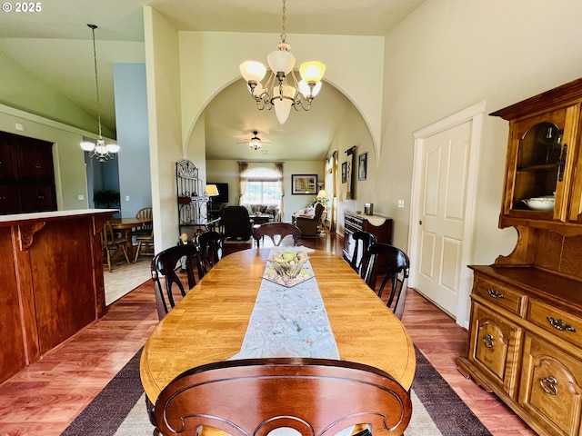 2295 Chi Chi Ln, Sutherlin, OR 97479 - dining space featuring a chandelier, ceiling fan, high vaulted ceiling, arched walkways, and wood finished floors
