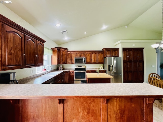 2295 Chi Chi Ln, Sutherlin, OR 97479 - kitchen featuring stainless steel appliances, vaulted ceiling, light countertops, a sink, and a center island with sink
