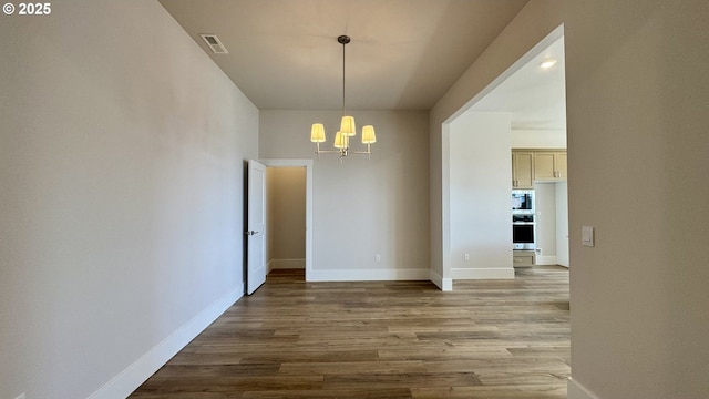 17880 SW Alvord Ln, Beaverton, OR 97007 - unfurnished dining area featuring visible vents, baseboards, an inviting chandelier, and wood finished floors