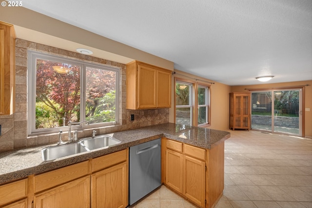 kitchen with a sink, decorative backsplash, a peninsula, and dishwasher