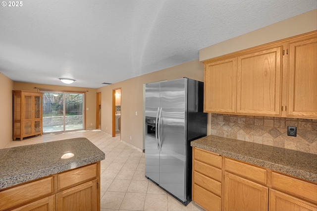 kitchen with stainless steel fridge with ice dispenser, open floor plan, tile countertops, tasteful backsplash, and light tile patterned floors