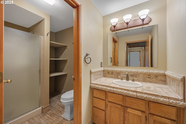 bathroom with vanity, a stall shower, and toilet
