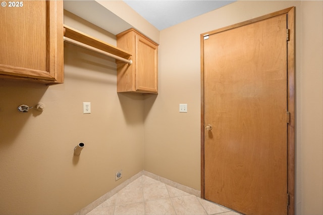 laundry area with baseboards, cabinet space, light tile patterned floors, and hookup for an electric dryer