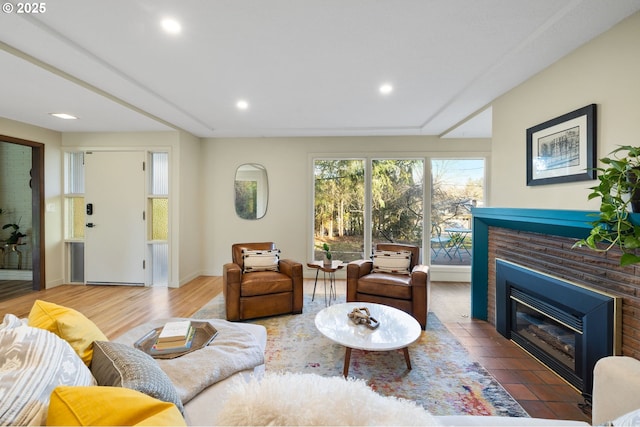 living room with hardwood / wood-style flooring and a brick fireplace