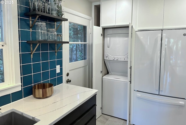 clothes washing area with stacked washer and clothes dryer