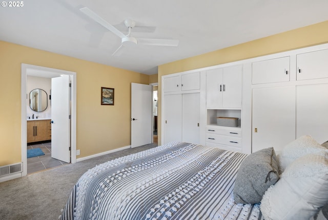 bedroom with light carpet, ensuite bath, and ceiling fan