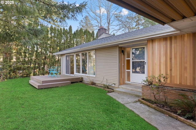 doorway to property featuring a wooden deck and a lawn