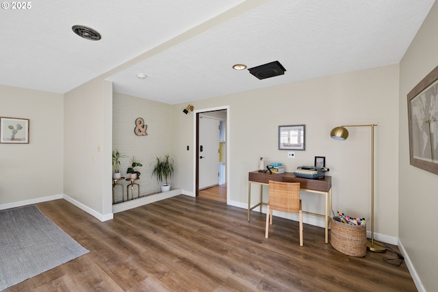 office area with dark hardwood / wood-style floors and a textured ceiling