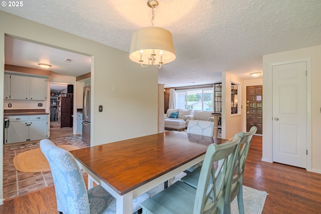 dining space featuring a textured ceiling and wood finished floors