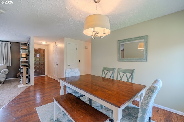 dining room featuring baseboards, a textured ceiling, and wood finished floors