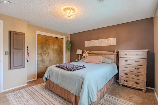 bedroom featuring baseboards, a closet, a textured ceiling, and light colored carpet