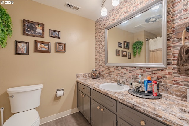 full bath with vanity, toilet, decorative backsplash, wood finished floors, and visible vents