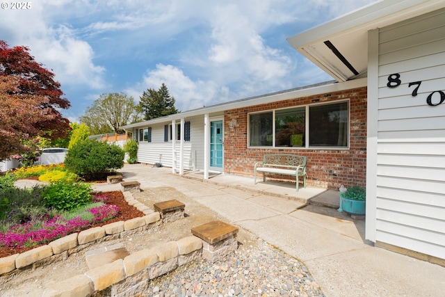 entrance to property featuring brick siding